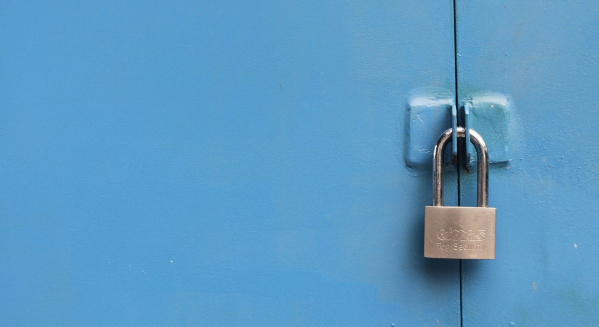 Steel padlock on a blue surface